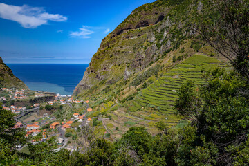 Krajobraz górski z widokiem na ocean. Portugalskie krajobrazy z niebieskim niebem i widokiem na lazurowy ocean na wyspie Madera. Podróże i wakacje na Maderze.	