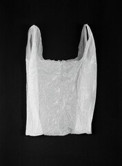 White Plastic Bag on Black Background. Old Crumpled Plastic Bag, Used Cellophane Packaging Waste, Shopping Disposable Pouch