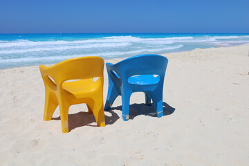 Blue and yellow chairs at sea beach, North coast of Egypt