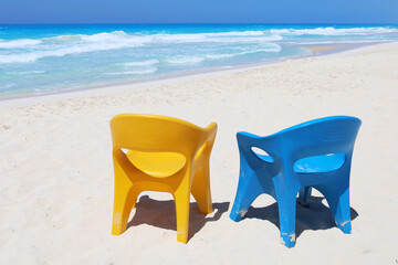 Two beach chairs at paradise sea coast, blue and yellow trendy Ukrainian colors, vacation background