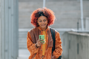 Fototapeta premium young afro american woman with mobile phone in the street