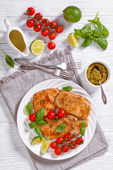 tomato basil pesto fried pork cutlets on plate