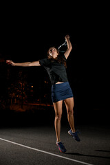 active female tennis player with tennis racket in her hand bouncing to hit the tennis ball.