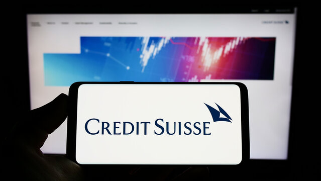 Stuttgart, Germany - 10-14-2022: Person holding smartphone with logo of Swiss financial company Credit Suisse Group AG on screen in front of website. Focus on phone display.