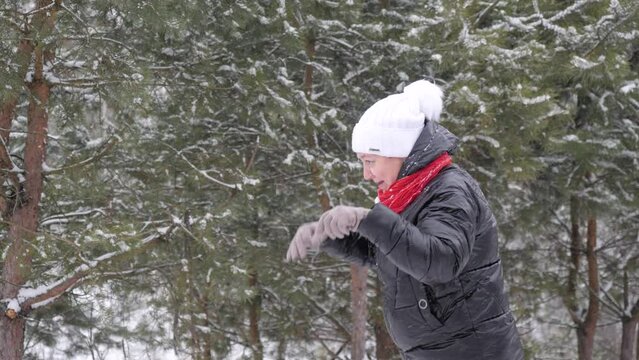 Woman playing with snow outdoors in the forest