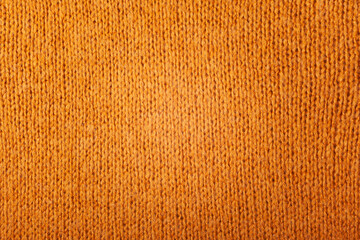 Autumn concept - background of knitted woolen brown sweater. Knit fabric texture. Close up view....