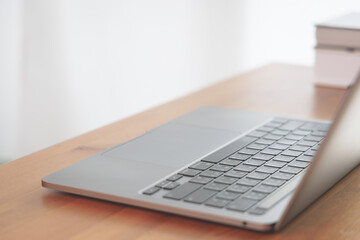 closeup of laptop computer keyboard on the wooden table. Online portable working technology and communication concept.