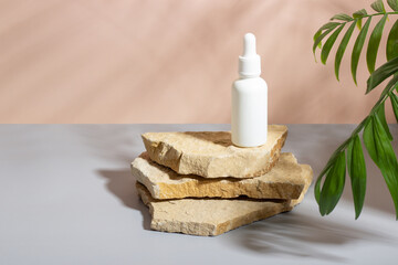 Face and body skin care products with a pipette on a beige background on a stone podium. Professional cosmetics for skin care. Organic cosmetics. Cosmetics for women with natural ingredients.