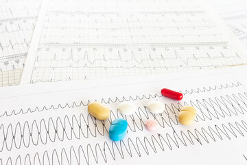 Electrocardiogram with ventricular tachycardia and some colored pills.