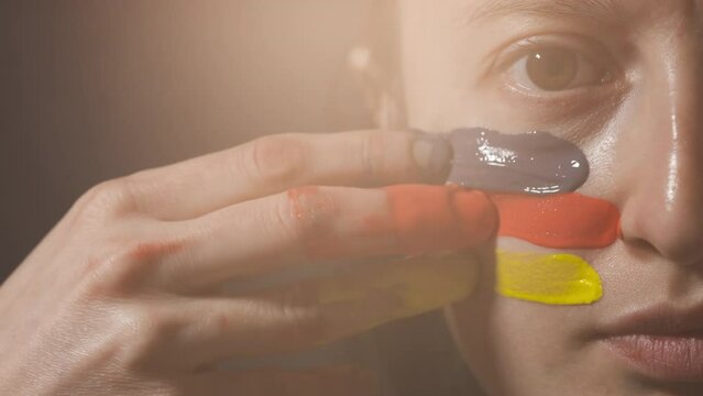 Supporter Painting Face and Looking at Camera. Football Fan Preparing for the Match. Colored Face with Flag Colors Yellow, Red and Black. Slow Motion 4K Prores 422