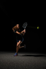 Fototapeta na wymiar beautiful view of tennis ball flying in the air and athletic woman tennis player with racket