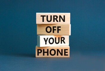 Turn off your phone symbol. Concept words Turn off your phone on wooden blocks. Beautiful grey table grey background. Business, psychological turn off your phone concept. Copy space.