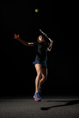 Fototapeta na wymiar view on female tennis player with tennis racket bouncing to hit yellow tennis ball.