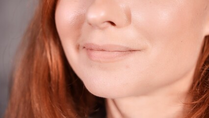 Obraz premium Closeup shot of a smile of a Caucasian female with red hair.