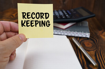 In the hands of a man is a sticker with the inscription - Record keeping