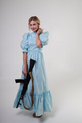 Beautiful woman in vintage blue dress with assault rifle