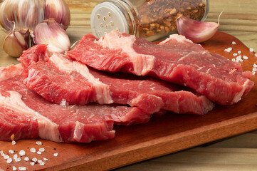 Raw beef steak on cutting board.