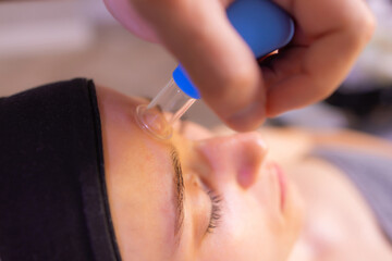 Woman receives facial cupping massage facial rejuvenation at acupuncture wellness spa.