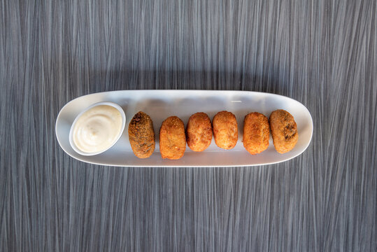 ham croquettes with sauce over a white plate
