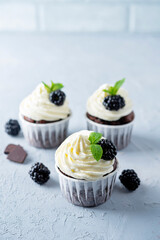 Chocolate banana cupcakes with cream cheese frosting and blackberries