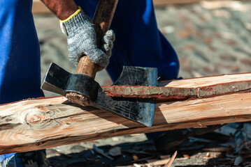 Man clearing trunk bark with ax