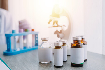 biochemical research scientist team working with microscope for coronavirus vaccine development in pharmaceutical research labolatory, selective focus