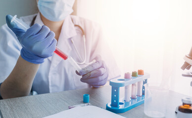 Obraz premium biochemical research scientist team working with microscope for coronavirus vaccine development in pharmaceutical research labolatory, selective focus