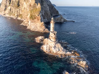 Foto op Canvas The abandoned lighthouse Aniva in the Sakhalin Island,Russia. Aerial View. © larisa_stock