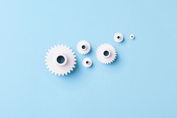 Flat lay white gears wheels symbolizing idea, cooperation, teamwork and connection concept	
