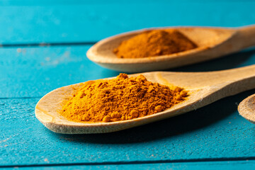 Wooden spoons with spices on a blue rustic wooden table