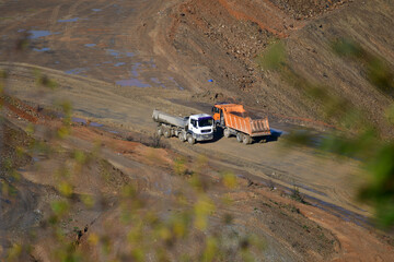 Fototapeta na wymiar Large trucks transport excavated earth and rocks for highway construction