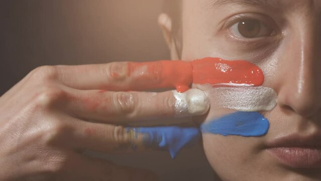 Supporter Painting Face and Looking at Camera. Football Fan Preparing for the Match. Colored Face with Flag Colors Red, White and Blue. Slow Motion 4K Prores 422
