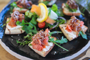 Catering table with salmon bruschetta, beautifully decorated banquet with food snacks appetizers on corporate birthday party event or wedding celebration, canape, delicatessen setting