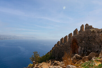 Fototapeta na wymiar the old wall of the ancient castle is visible against the blue sea. High quality photo