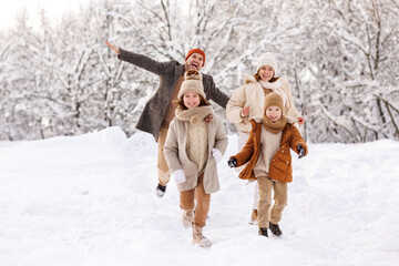 Happy kids have fun with parents outdoor in winter park, family rejoice snowy weather in forest