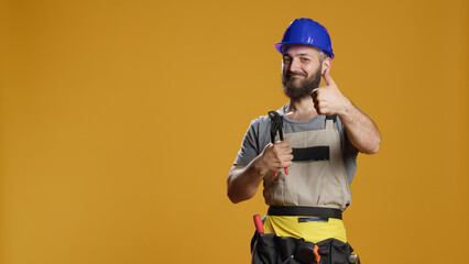 Portrait of craftsman showing thumbs up gesture in studio, expressing approval and agreement....