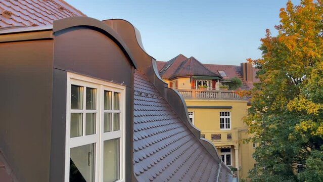 Window coming out of brown roof on residential building in Munich, Germany. Traditional Bavarian house construction. Top floor, attic concepts