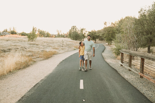 A Father walking with his step son outdoors 