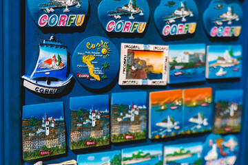 View of traditional tourist souvenirs and gifts from Kerkyra, Corfu island, Ionian sea, Greece, fridge magnets with text "Corfu","Greece" and key ring keychain, in local vendor souvenir shop kiosk