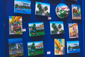 View of traditional tourist souvenirs and gifts from Kerkyra, Corfu island, Ionian sea, Greece, fridge magnets with text "Corfu","Greece" and key ring keychain, in local vendor souvenir shop kiosk