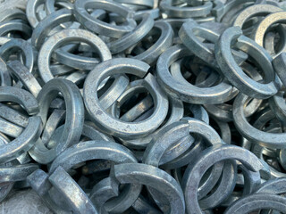 Background, texture of many metal small iron round washers for bolts and stainless steel fasteners, fittings and mitiz