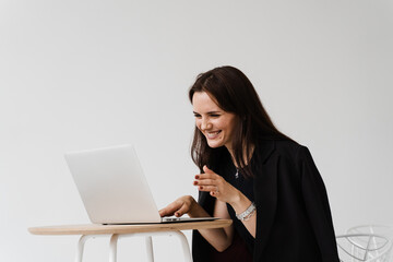 Video meeting with friends and colleagues and have fun online remotely after successful project. Girl with laptop smile, laughs and discussing funny situations at work with colleagues.