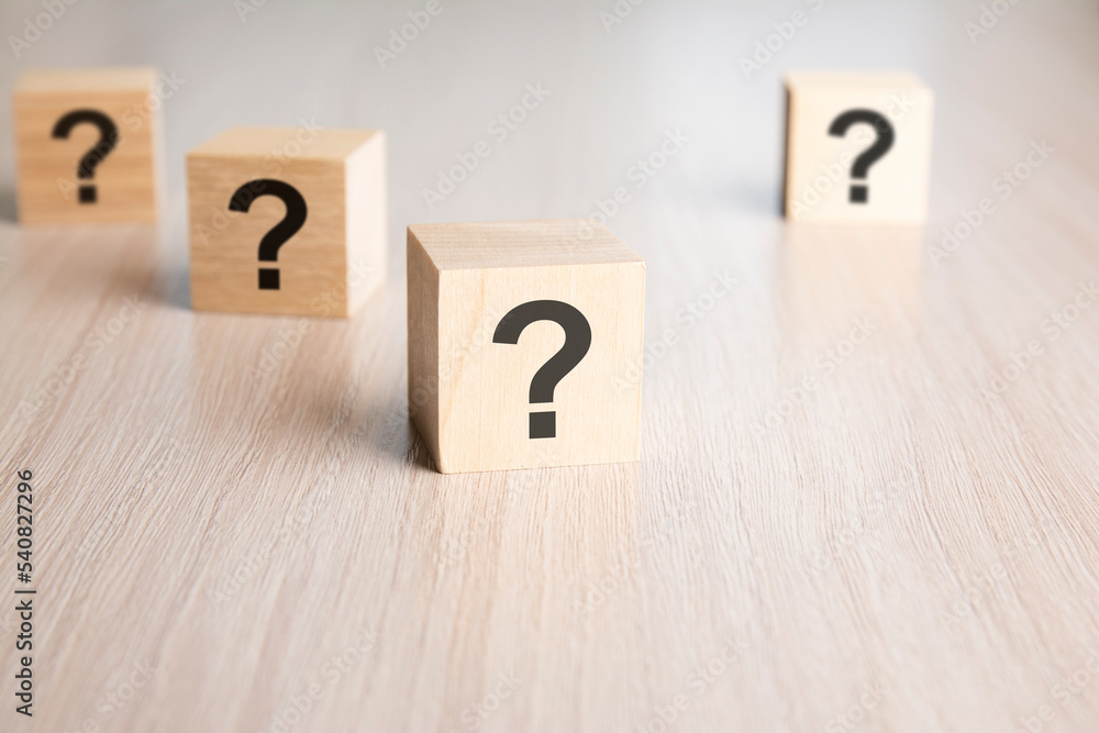 Poster front view on many wood cubes with question marks. many question arising concept