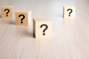 front view on many wood cubes with question marks. many question arising concept