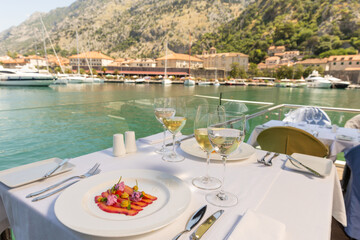 Fish filet on a plate served on a restaurant table with wine