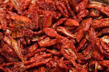 Pile of sun dried tomatoes typical for Italy. Food background. Shallow depth of field.