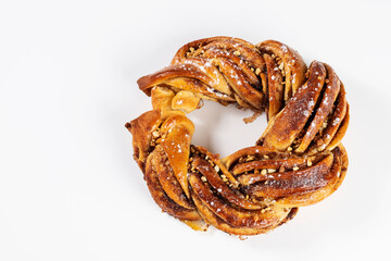 Roscón de reyes Kringle Estonia. Typical Christmas sweet, braided sponge cake with cinnamon, butter, walnuts or almonds and icing sugar on a white background.