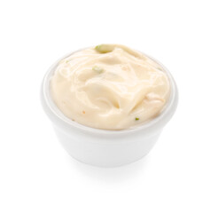 Caesar salad dressing in bowl on white background