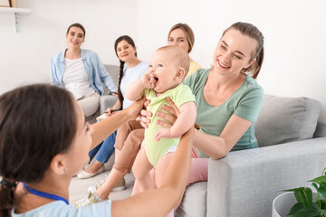 Female speaker with little baby giving course for expectant mothers in class