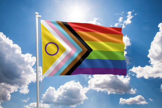Intersex-inclusive pride flag. New LGBTQIA+ Progress pride flag. Progress flag symbol in the lgbt community. Blue sunny sky with clouds.